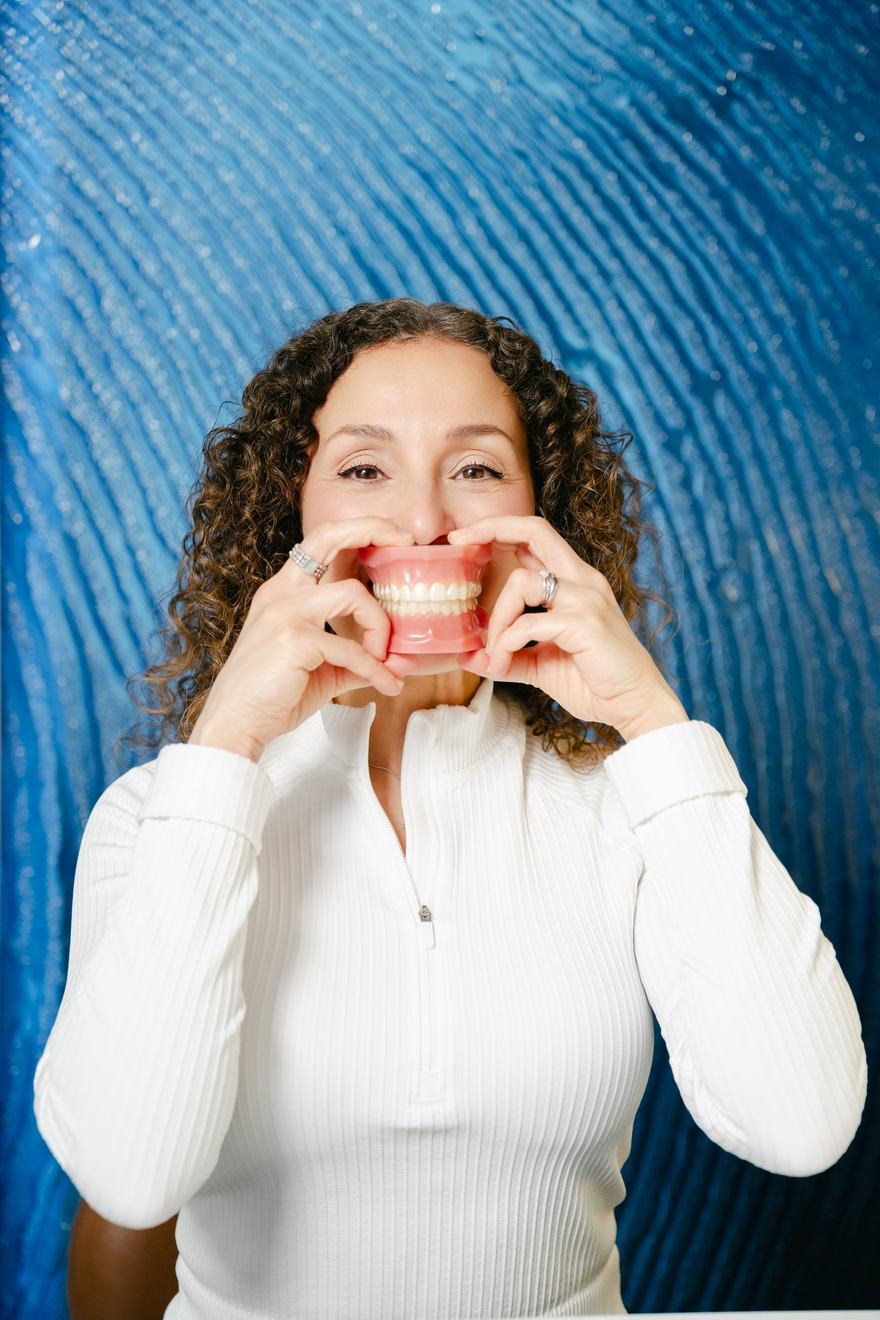 A member of the Downtown Orthodontics team holding a clear retainer
