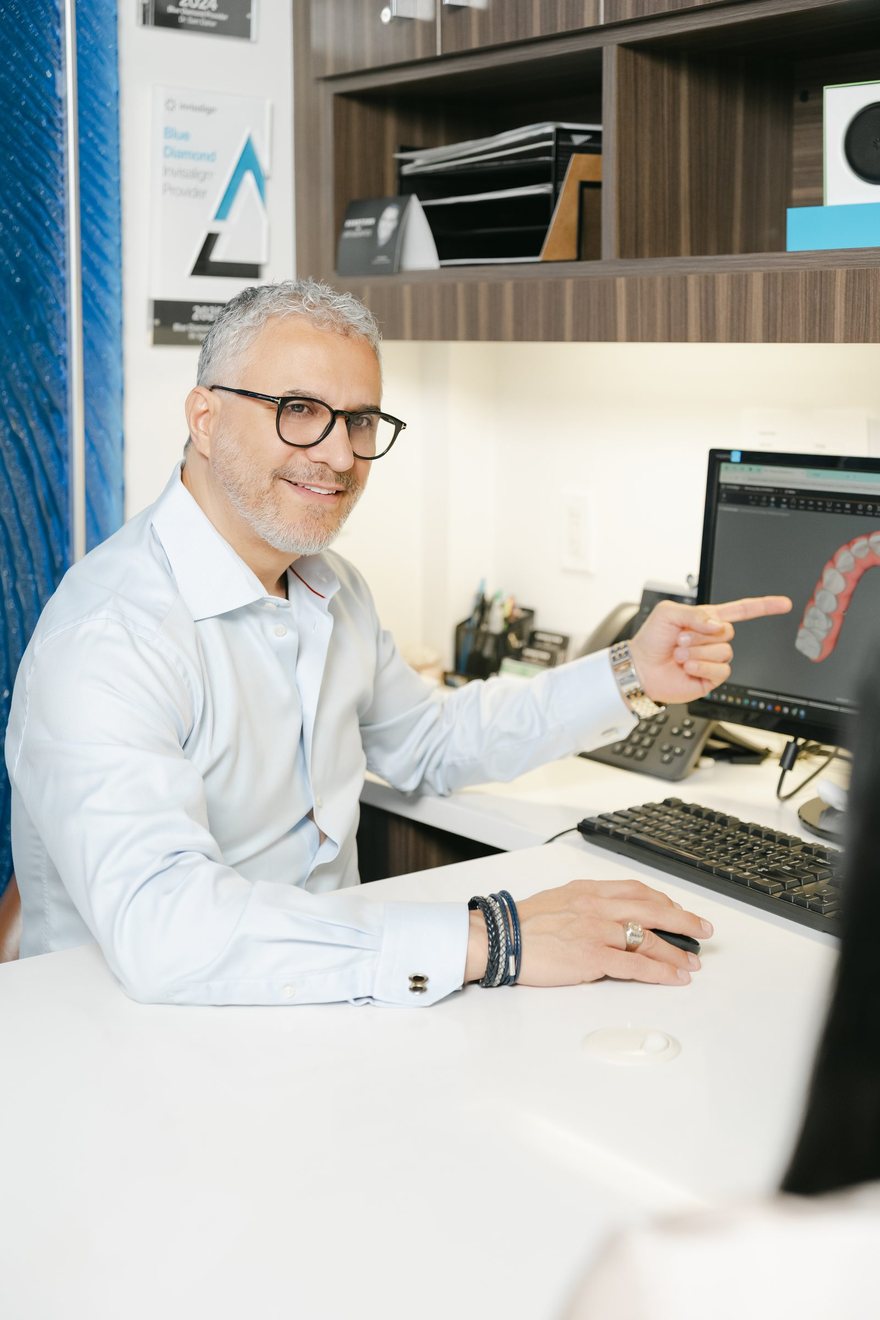 Dr. Daher explaining a braces treatment plan at his consultation desk
